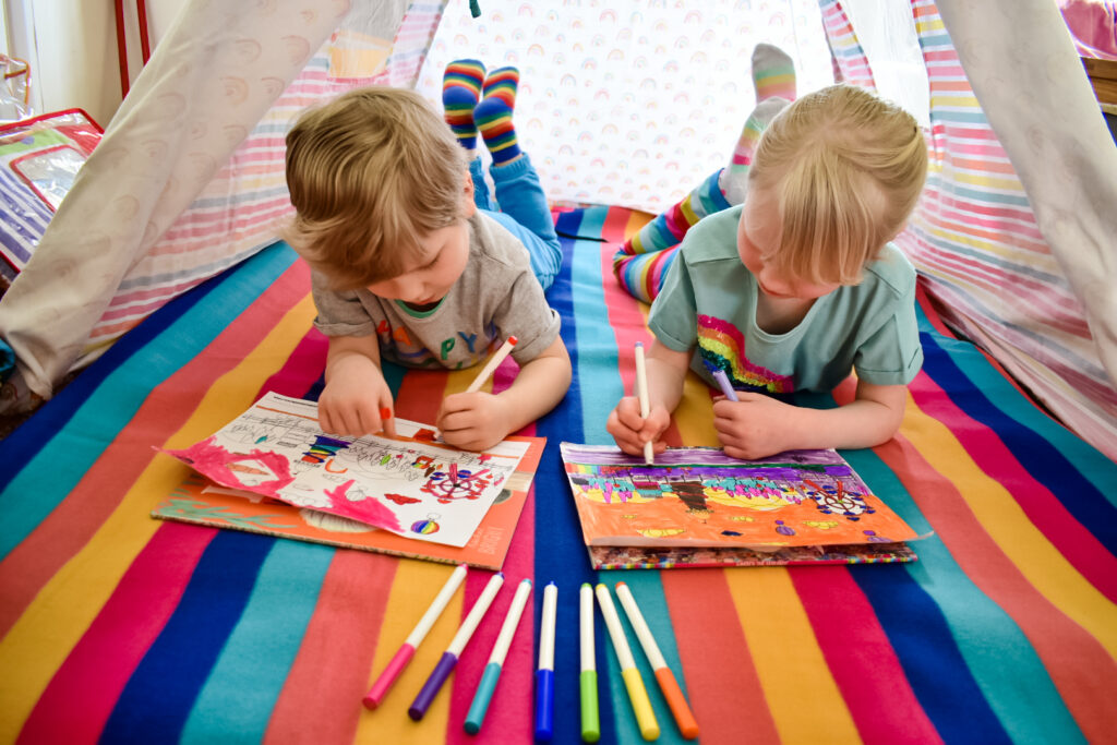 twins colouring in teepee with lockdown hair