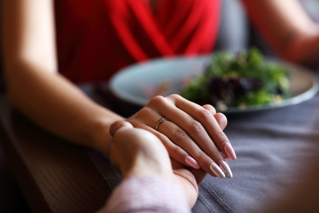 Couple holding hands at dinner