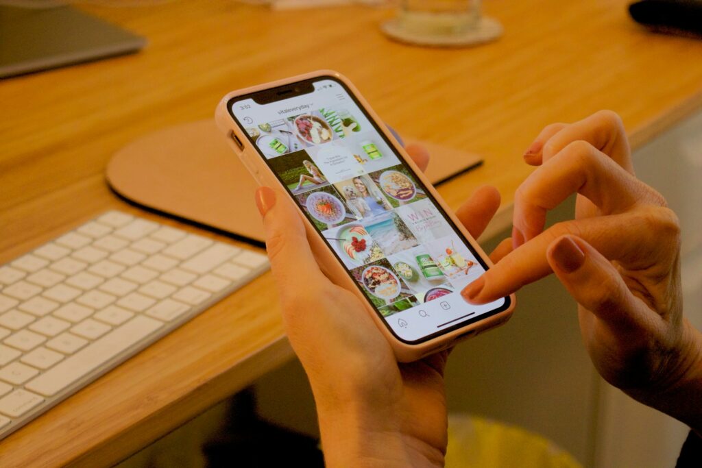 Person's hands scrolling Instagram feed on a phone