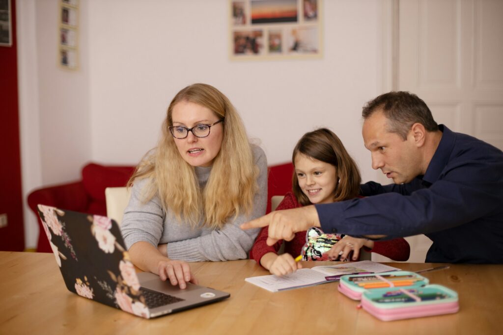 child doing online tutoring with parents