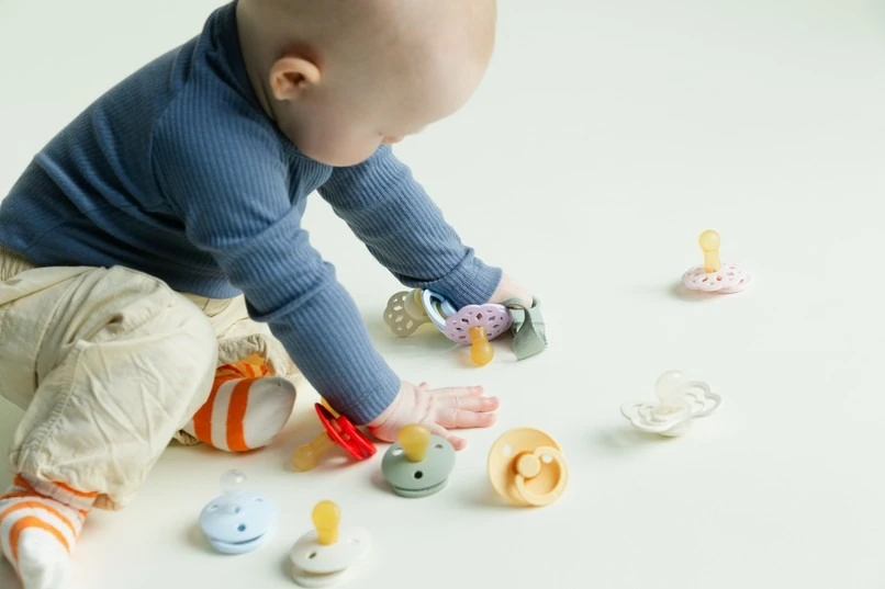 baby playing with pacifiers
